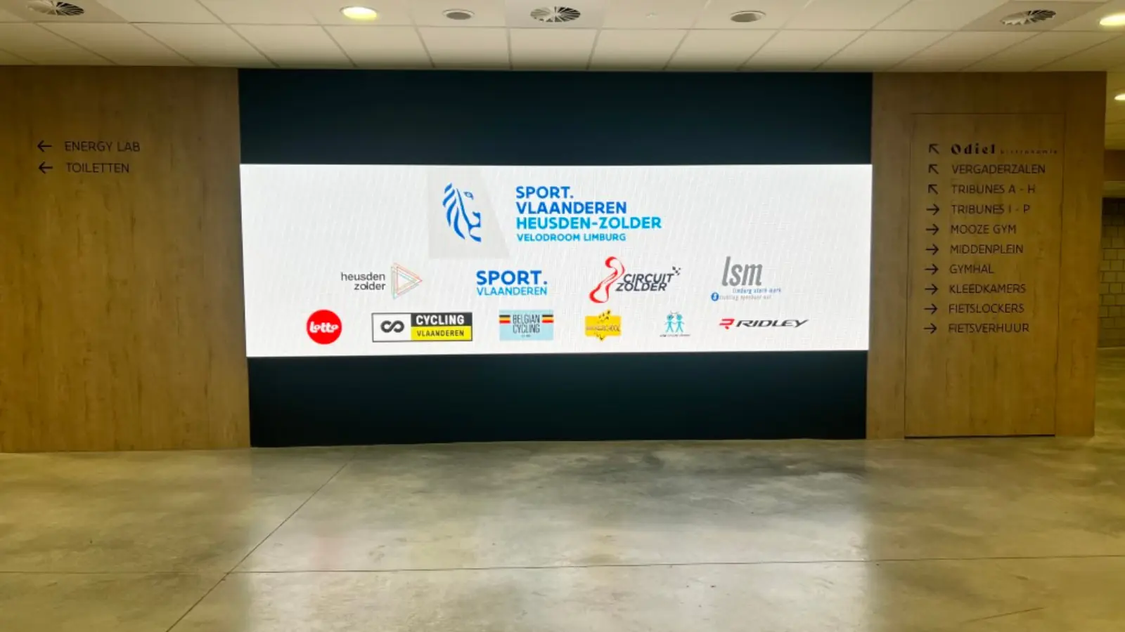LED-wand met sponsorlogo's in de onthaalzone van een wielercentrum